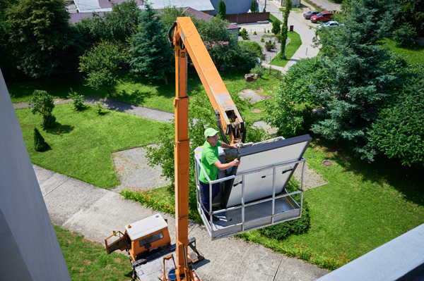 Ein Arbeiter, der auf einer Hubarbeitsbühne steht.