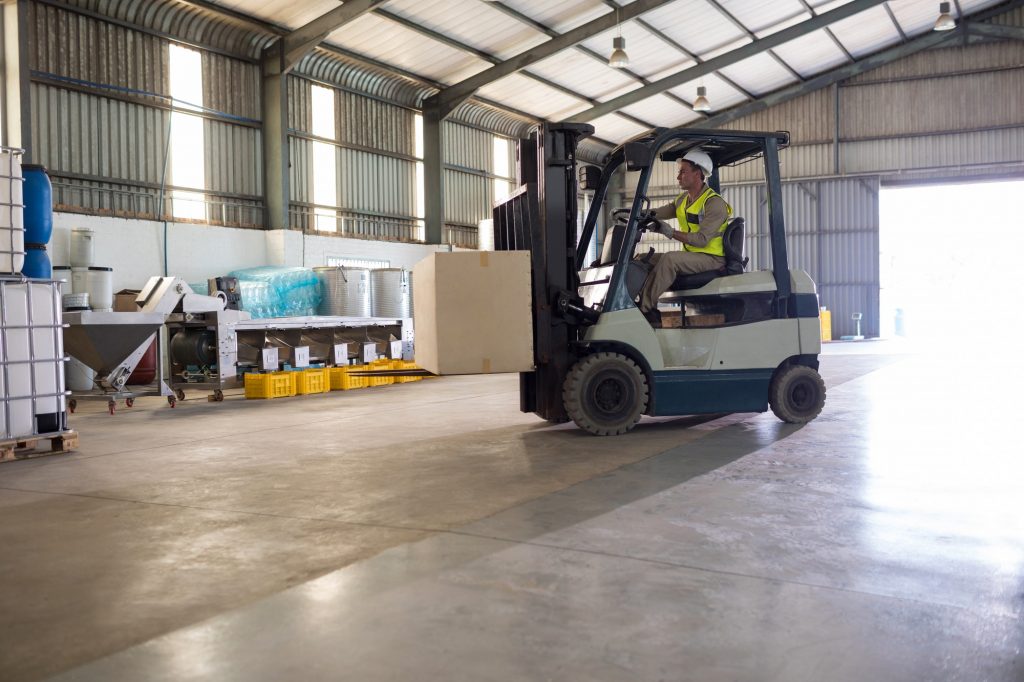 Worker carrying package with forklift
